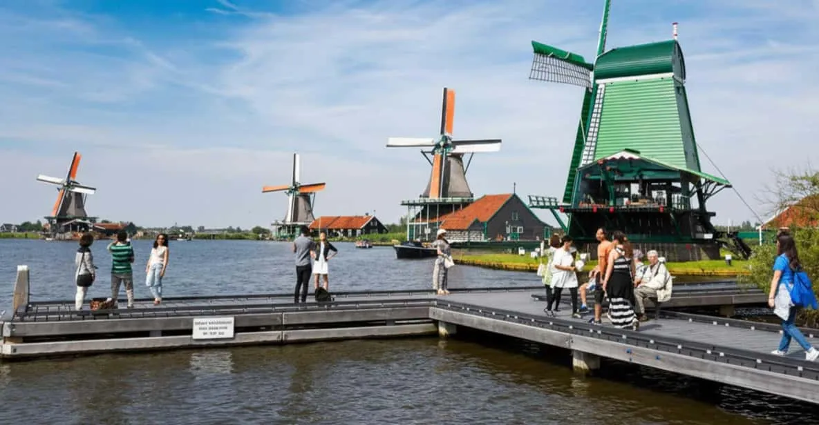 Seventeenth-century wooden houses and a windmill reflected in the water at Zaanse Schans on a full-day Amsterdam windmill tour