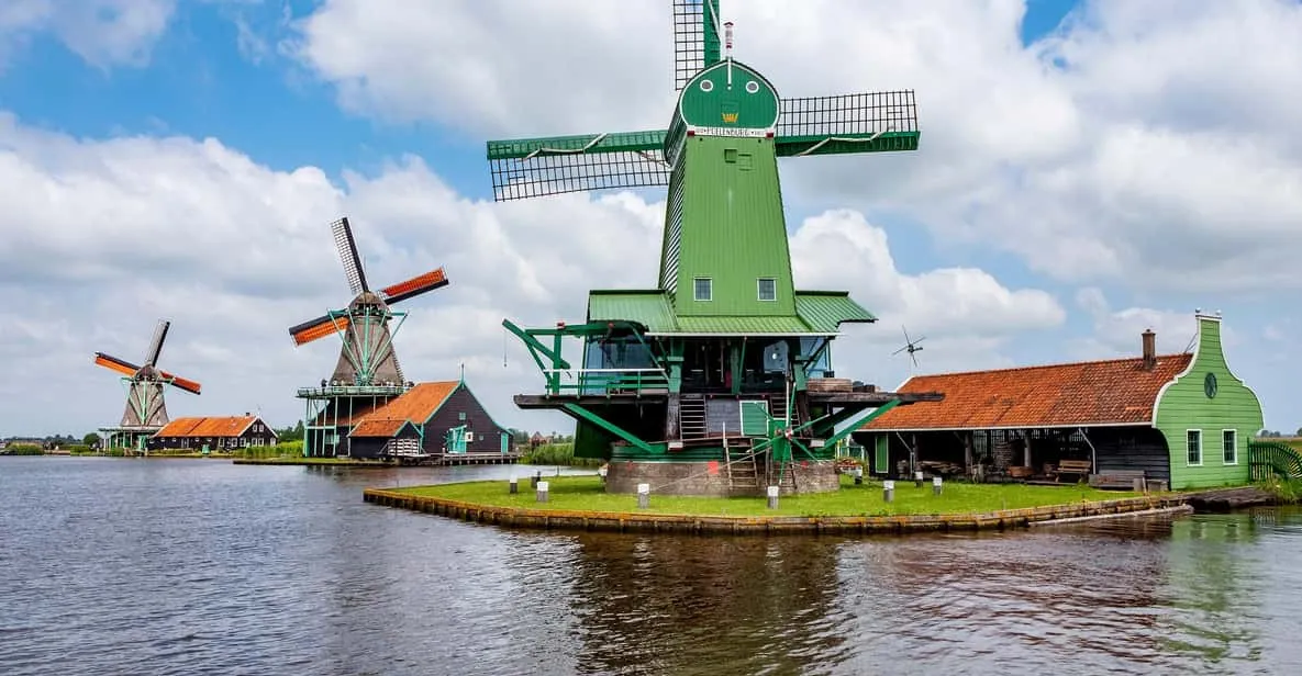 Small group beside a working windmill and cheese farm on a bilingual Amsterdam windmill tour to Zaanse Schans and Volendam